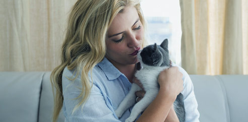 woman kissing cat